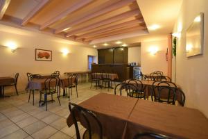a dining room with tables and chairs and a kitchen at Logis Hôtel Saint Jacques in Valence