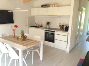 eine Küche mit einem Holztisch und weißen Schränken in der Unterkunft Bootshaus Mirow in Mirow