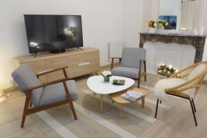 sala de estar con TV, mesa y sillas en Arles Getaway - La Suite Arlésienne en Arlés