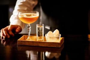 a drink in a glass sitting on a table with a tray at ABode Manchester in Manchester