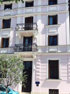 a white building with balconies and a car parked in front at Apartments Villa Castello in Crikvenica