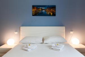 a bedroom with a white bed with two towels on it at Bongiorno Home Private Free Parking Venice 10' in Marghera