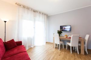 a living room with a red couch and a dining room table at Bongiorno Home Private Free Parking Venice 10' in Marghera