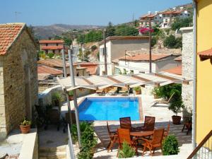 una piscina con sombrillas y sillas junto a un edificio en Anesi House, en Skarinou