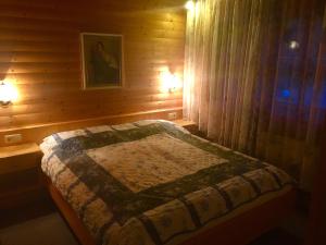 1 dormitorio con 1 cama en una cabaña de madera en Appartement Gnaiger, en Forstau