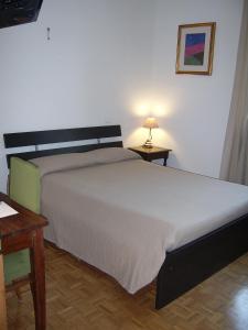 ボローニャにあるB&B La Zuccaのベッドルーム(ベッド1台、テーブル、ランプ付)
