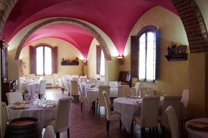 a dining room with white tables and chairs and pink ceilings at Bacco a Petroio in Vinci