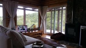 a living room with a couch and a large window at El Ahora in El Eden