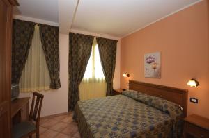 a hotel room with a bed and a window at Sun Garden in San Vito lo Capo