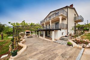 a large house with a wooden deck in front of it at Apartment Sandro in Vilanija