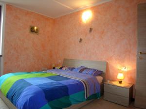 een slaapkamer met een bed met een kleurrijk dekbed bij Casa Gabriella in San Siro