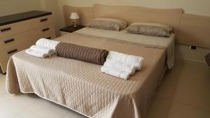 マリーナ・ディ・マンカヴェルサにあるAppartamenti Emblema Mancaversaのベッドルーム1室(ベッド2台、タオル付)