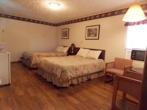 um quarto de hotel com duas camas e uma cadeira em Clarketon Motel - Maggie Valley em Maggie Valley