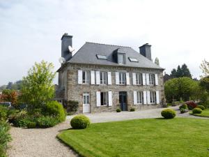 an old stone house with a garden in front of it at Gîte Sourdeval in Sourdeval