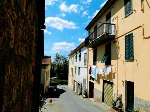 an alley with clothes hanging on a clothes line between two buildings at Appartamento Borgo in Suvereto