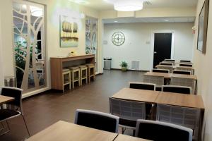 a restaurant with tables and chairs and a clock on the wall at Microtel Inn & Suites by Wyndham - Penn Yan in Penn Yan