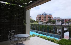 a balcony with a table and a view of a river at 005 Marina Apartment in Cape Town