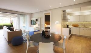 cocina y sala de estar con mesa y sillas en 005 Marina Apartment en Ciudad del Cabo