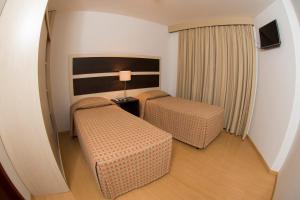 a hotel room with two beds and a lamp at Lagoa Serena Flat Hotel in Araras +34 photos