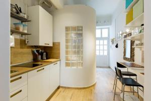a kitchen with white cabinets and a table and chairs at Buda Castle Apartment in Budapest