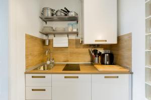 a kitchen with white cabinets and a sink at Buda Castle Apartment in Budapest +23 photos