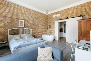 a bedroom with a bed and a brick wall at Buda Castle Apartment in Budapest