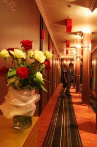 Ein Paar steht im Flur mit einer Vase Rosen in der Unterkunft Annabelle отель in Odessa