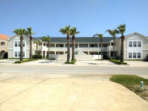 an empty street in front of a building with palm trees at Bahama Breeze #2 Sea Dancer Condos in South Padre Island