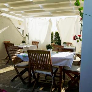 un ristorante con tavoli e sedie con tovaglia bianca di B&B Corte Regina Esther a Veglie