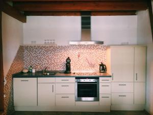 a kitchen with white cabinets and a stove top oven at Biohof Zahn in Hockenheim