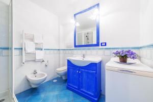 uma casa de banho com um lavatório, um WC e um espelho. em La Luella em Sorrento