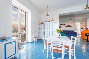 uma cozinha e sala de estar com uma mesa branca e cadeiras em La Luella em Sorrento