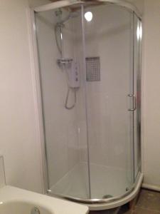a shower with a glass door in a bathroom at The Old Post Office,Hassocks in Ditchling