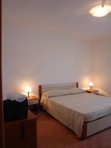 マリーナ・ディ・マンカヴェルサにあるVille Amalfiのベッドルーム1室(ベッド1台、ランプ付きテーブル2台付)