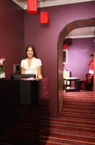 a woman standing at a counter in a room with a mirror at Annabelle отель in Odesa