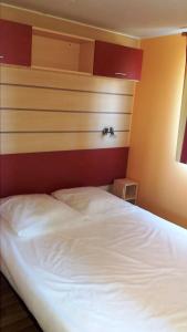 a bedroom with a white bed with a red headboard at La Canardiere in Casta