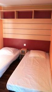 two beds in a small room with red walls at La Canardiere in Casta