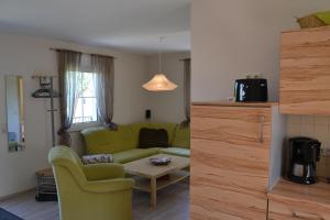 ein Wohnzimmer mit einem grünen Sofa und einem Tisch in der Unterkunft Töpferpark in Olbersdorf