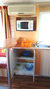 a small kitchen with a sink and a microwave at La Canardiere in Casta
