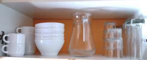 a shelf with several glass vases and cups on it at La Canardiere in Casta
