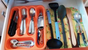 an orange tray filled with utensils on a table at La Canardiere in Casta