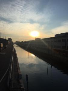 a river with the sun setting in the distance at Living in Milan