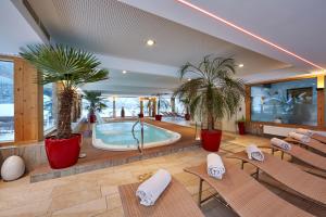 a hotel lobby with a swimming pool and chairs at Romantik Alpenhotel Waxenstein in Grainau