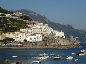 a group of boats in the water in front of a mountain at Gardenia in Amalfi
