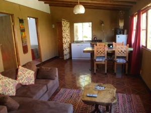 een woonkamer met een bank en een tafel bij Cabaña Canto del Viento, 4 personas in Horcon