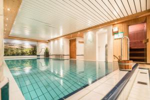 a large swimming pool in a building at Hotel Rose in Bretzfeld