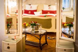 a room with a table with flowers and a bed at Romantik Hotel Deutsches Haus in Pirna