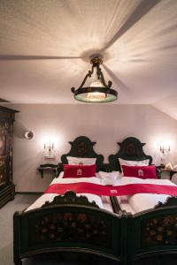 a bedroom with a large bed with red and white pillows at Romantik Hotel Deutsches Haus in Pirna