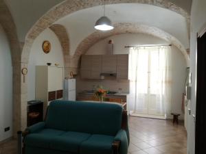 un soggiorno con divano blu e una cucina di Porta Nuova a Putignano