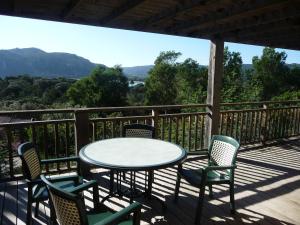 einen Tisch und Stühle auf einer Terrasse mit Aussicht in der Unterkunft Villa Les Hameaux Di Santa Giulia in Porto-Vecchio